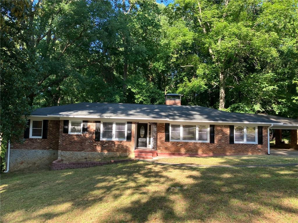 ranch-style house with a front yard and a carport