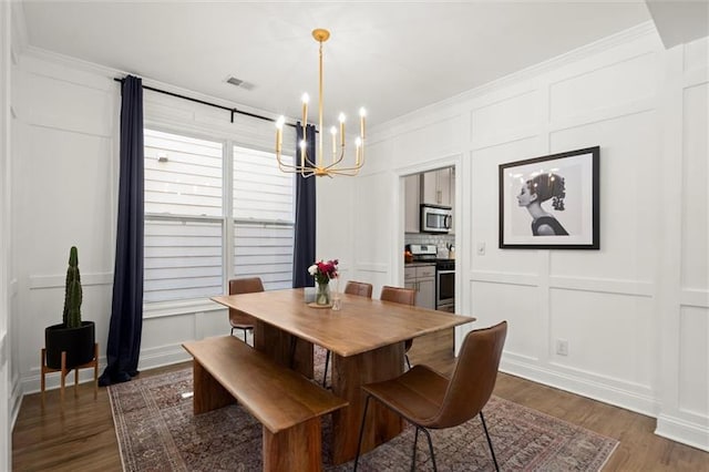 1744 Habershal Rd NW, Atlanta, GA 30318 - dining space with a decorative wall, a chandelier, dark wood-type flooring, and crown molding