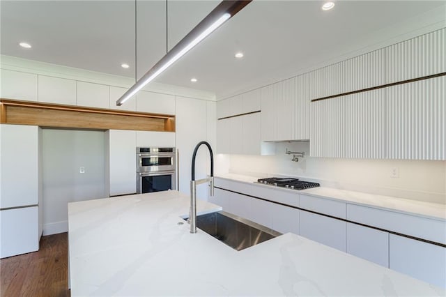 kitchen with white cabinetry, light stone countertops, sink, and appliances with stainless steel finishes