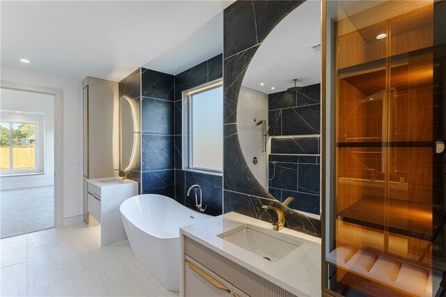 bathroom with tile patterned floors, vanity, tile walls, and plus walk in shower