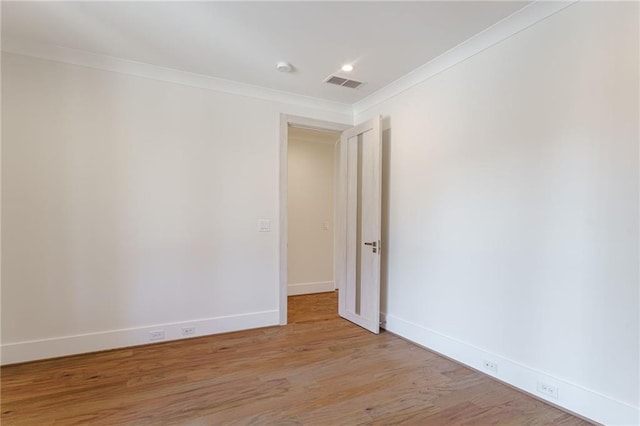 unfurnished room featuring light hardwood / wood-style floors and crown molding