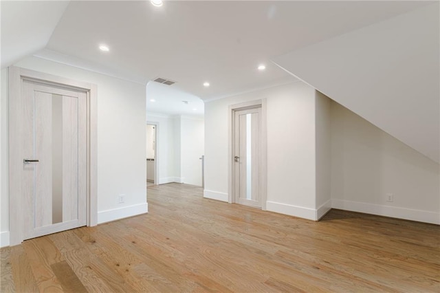 additional living space with light hardwood / wood-style floors and vaulted ceiling