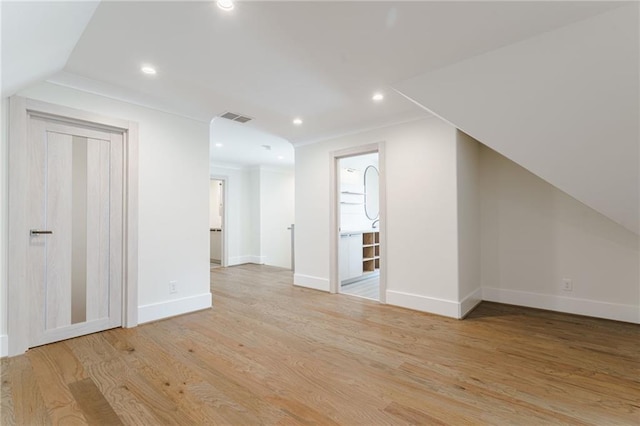 additional living space featuring light wood-type flooring and vaulted ceiling