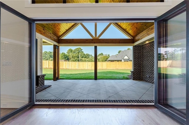 doorway to outside featuring hardwood / wood-style flooring, vaulted ceiling, and wood ceiling