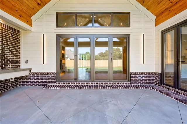 view of exterior entry with french doors and a patio area