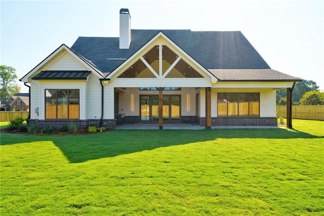 rear view of house with a lawn, ceiling fan, and french doors