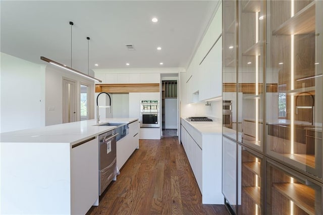 kitchen featuring pendant lighting, dark hardwood / wood-style flooring, white cabinetry, and a kitchen island with sink