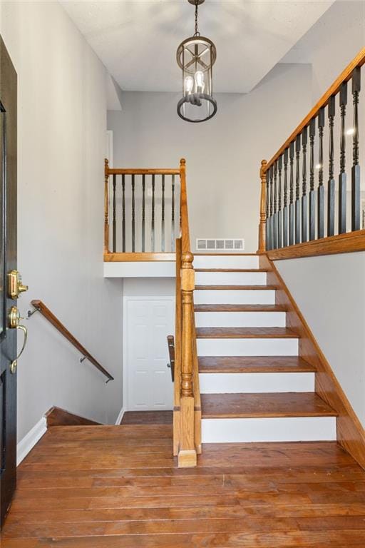 stairs with visible vents, baseboards, and wood finished floors