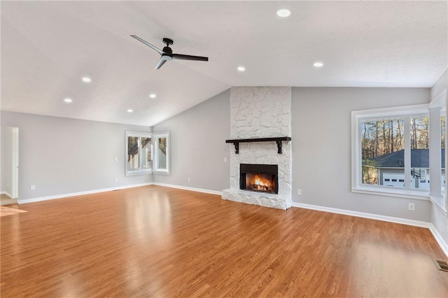 unfurnished living room with a healthy amount of sunlight, wood finished floors, ceiling fan, and vaulted ceiling