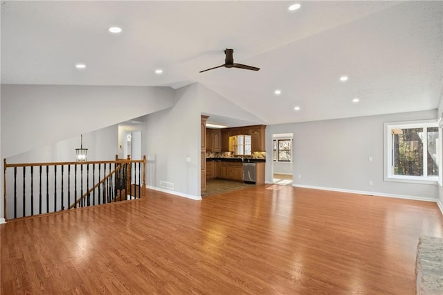 unfurnished living room featuring plenty of natural light, visible vents, lofted ceiling, and a ceiling fan