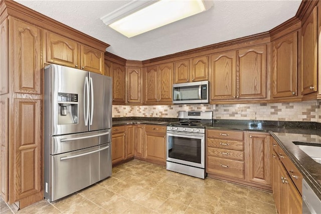 kitchen featuring brown cabinetry, backsplash, appliances with stainless steel finishes, and a textured ceiling