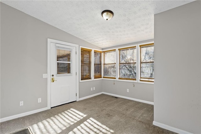 unfurnished room with lofted ceiling, carpet, baseboards, and a textured ceiling