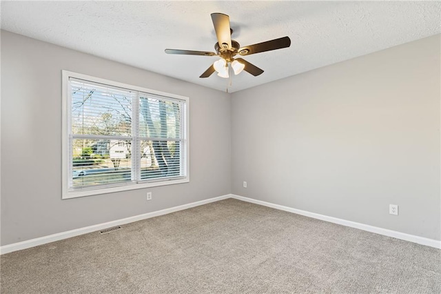 spare room featuring visible vents, a textured ceiling, baseboards, and ceiling fan