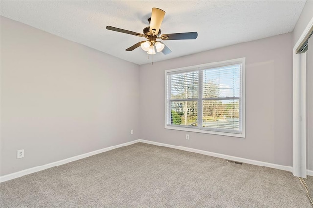 unfurnished bedroom featuring visible vents, baseboards, a textured ceiling, and carpet flooring