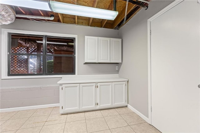 interior space with light tile patterned floors, white cabinets, and light countertops