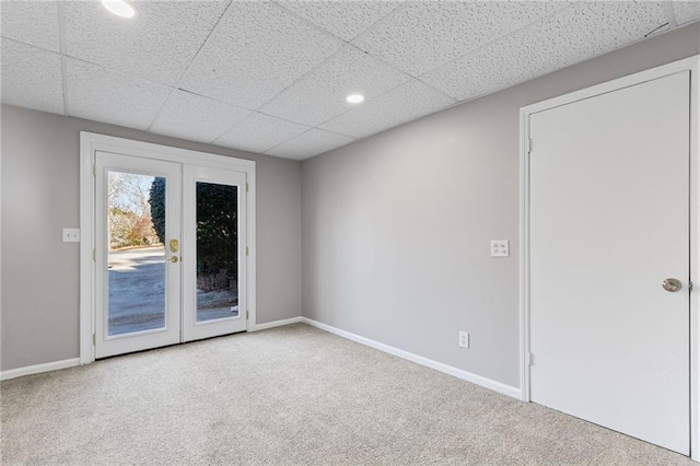 carpeted empty room with recessed lighting, french doors, a paneled ceiling, and baseboards