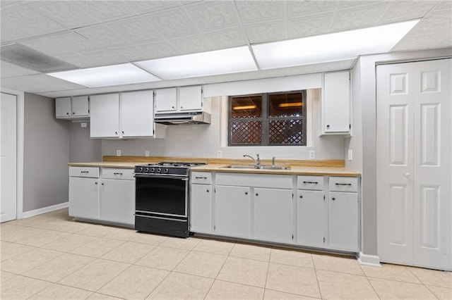 kitchen with a sink, under cabinet range hood, range with gas cooktop, light countertops, and baseboards