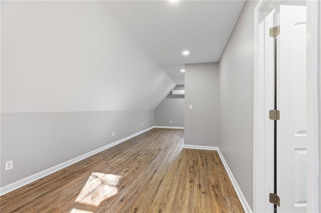 additional living space with vaulted ceiling, wood finished floors, and baseboards