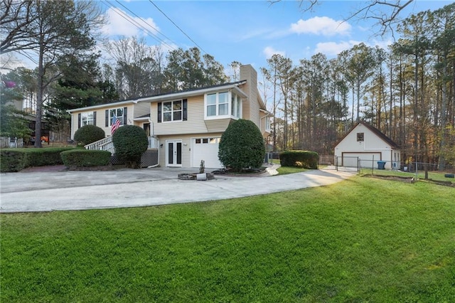 raised ranch with a front lawn, fence, a chimney, an outdoor structure, and driveway