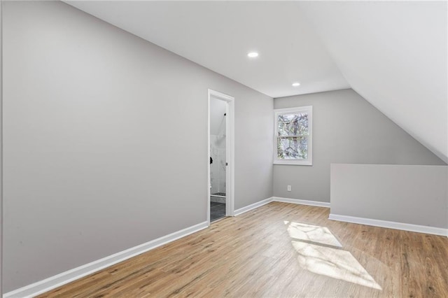 additional living space featuring lofted ceiling, recessed lighting, wood finished floors, and baseboards