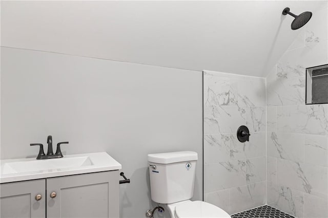 bathroom featuring tiled shower, toilet, and vanity