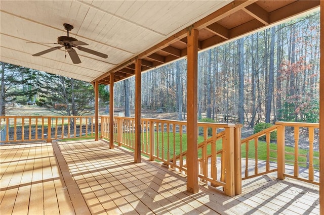 wooden terrace with a lawn and a ceiling fan