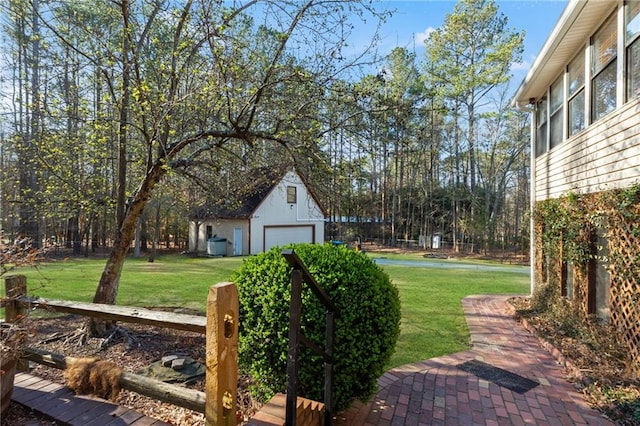 view of yard with a detached garage and an outbuilding