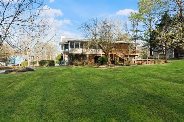 rear view of property featuring stairway, a yard, and a sunroom