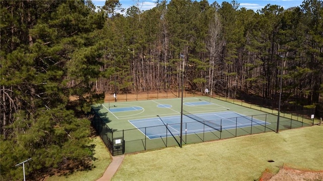 view of sport court with a tennis court, a view of trees, community basketball court, and fence