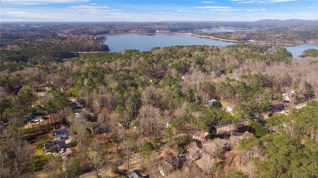 drone / aerial view with a wooded view and a water view