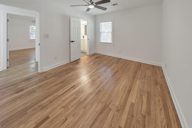 empty room featuring ceiling fan, a healthy amount of sunlight, and light wood-type flooring