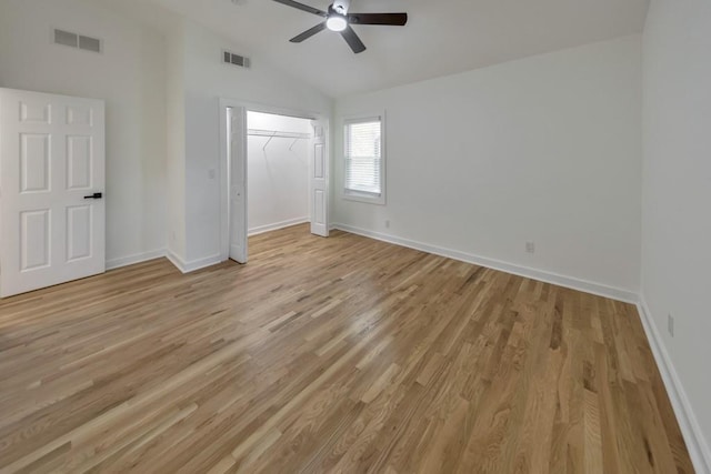 unfurnished bedroom featuring lofted ceiling, a closet, ceiling fan, and light wood-type flooring