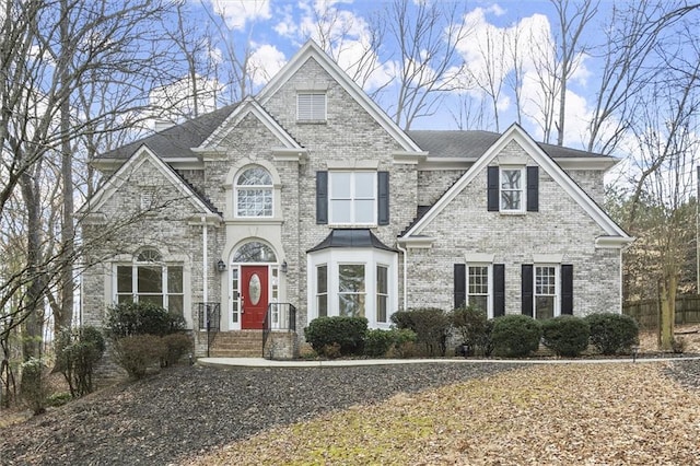 view of front of home with brick siding and a chimney