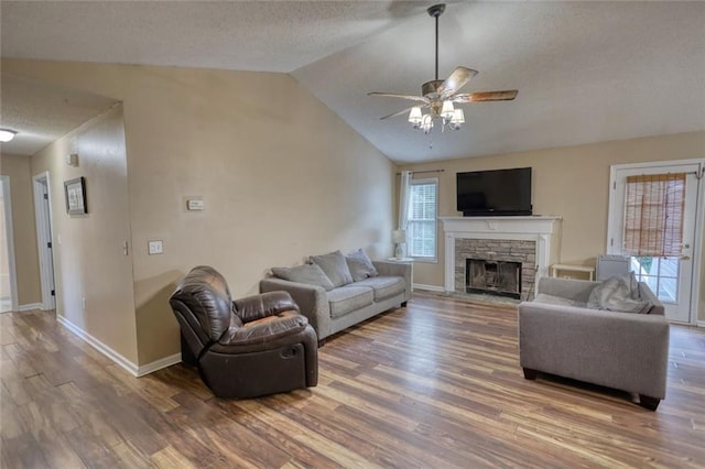 160 Riverbrooke Trl, Covington, GA 30016 - living area featuring lofted ceiling, wood finished floors, a textured ceiling, a fireplace, and a ceiling fan