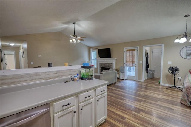 160 Riverbrooke Trl, Covington, GA 30016 - kitchen with a fireplace, wood finished floors, white cabinetry, decorative light fixtures, and light countertops