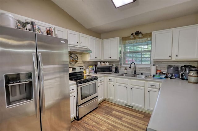 160 Riverbrooke Trl, Covington, GA 30016 - kitchen featuring appliances with stainless steel finishes, a sink, under cabinet range hood, white cabinetry, and light countertops