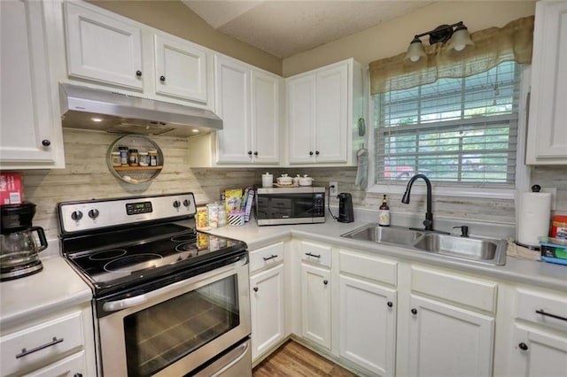 160 Riverbrooke Trl, Covington, GA 30016 - kitchen featuring appliances with stainless steel finishes, under cabinet range hood, a sink, light countertops, and decorative backsplash