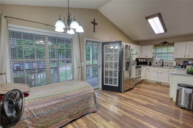 160 Riverbrooke Trl, Covington, GA 30016 - bedroom featuring stainless steel fridge, a sink, a chandelier, vaulted ceiling, and access to exterior