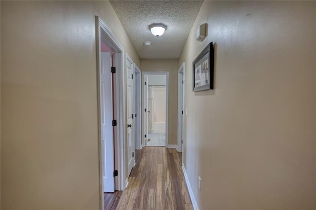 160 Riverbrooke Trl, Covington, GA 30016 - hallway featuring a textured ceiling, wood finished floors, and baseboards