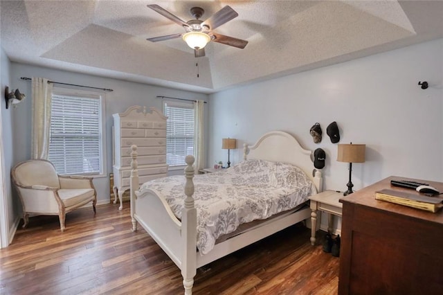 160 Riverbrooke Trl, Covington, GA 30016 - bedroom with dark wood finished floors, a raised ceiling, baseboards, a ceiling fan, and a textured ceiling