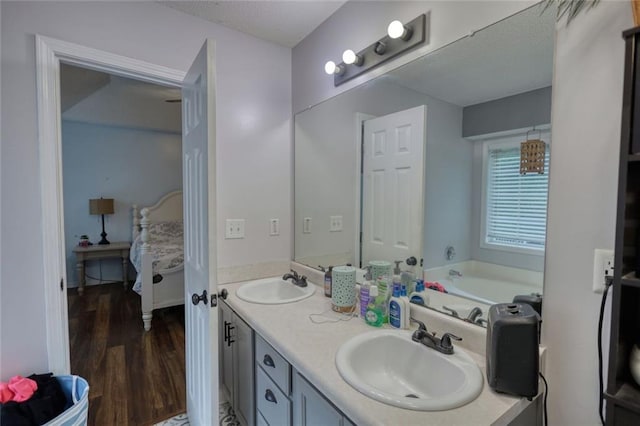 160 Riverbrooke Trl, Covington, GA 30016 - ensuite bathroom with wood finished floors, double vanity, a garden tub, and a textured ceiling