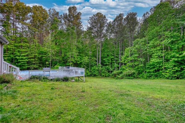 160 Riverbrooke Trl, Covington, GA 30016 - view of grassy yard featuring a deck, a wooded view, and an outdoor pool