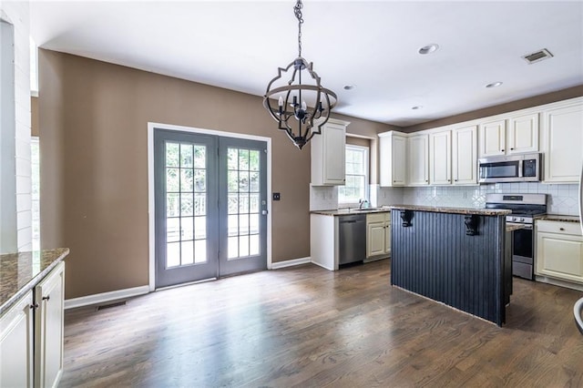 kitchen with stainless steel appliances, healthy amount of natural light, a chandelier, decorative backsplash, and recessed lighting