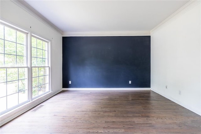 unfurnished room featuring ornamental molding, wood finished floors, and baseboards