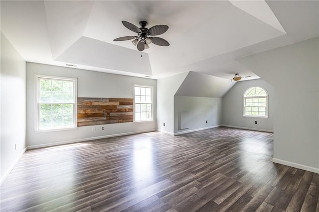 additional living space with dark wood-style flooring, ceiling fan, baseboards, and vaulted ceiling