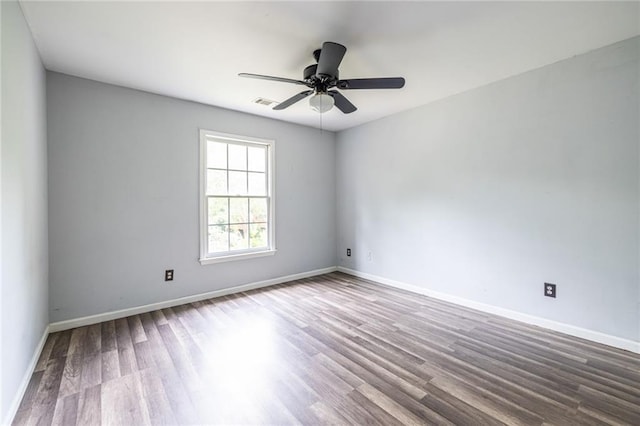 spare room featuring wood finished floors, baseboards, and ceiling fan