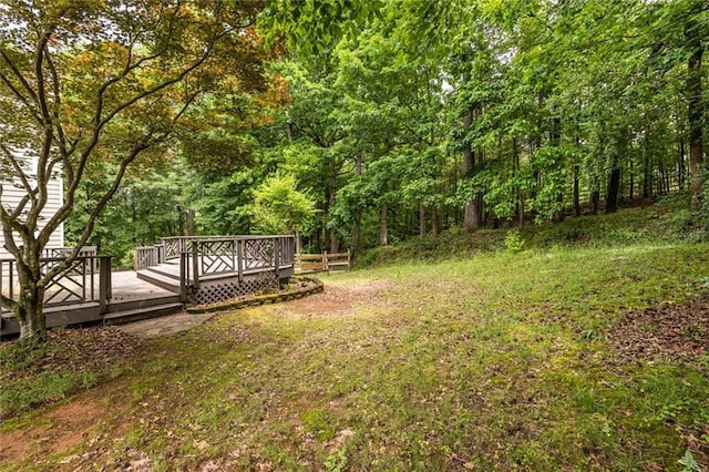 view of yard featuring a deck and a forest view