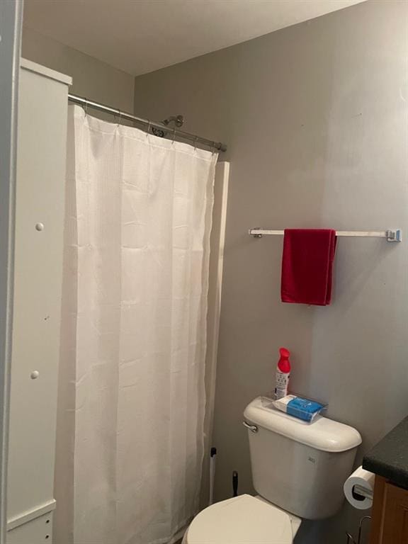 full bathroom featuring curtained shower, vanity, and toilet