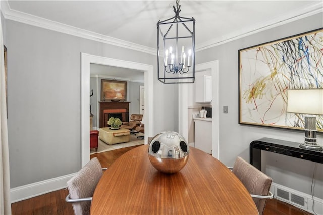 25 Standish Ave NW, Atlanta, GA 30309 - dining area featuring a chandelier, wood finished floors, crown molding, and baseboards