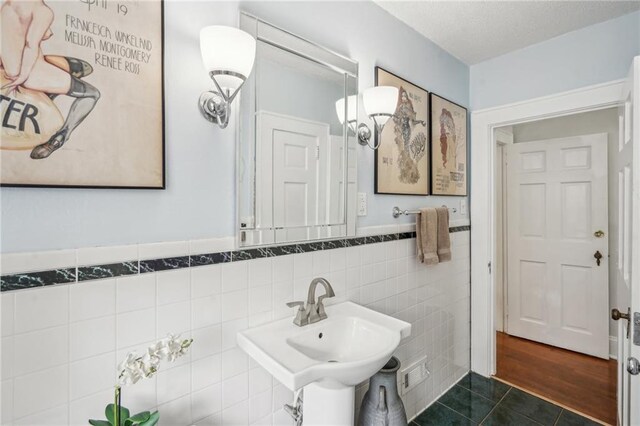 25 Standish Ave NW, Atlanta, GA 30309 - bathroom featuring tile walls, tile patterned floors, a wainscoted wall, and a sink